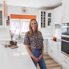 Long-haired woman in bright white shaker-style kitchen