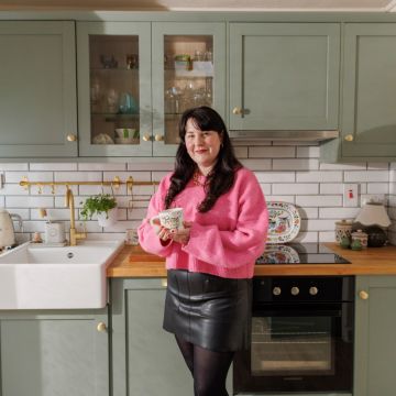 Long-haired woman in sage green kitchen