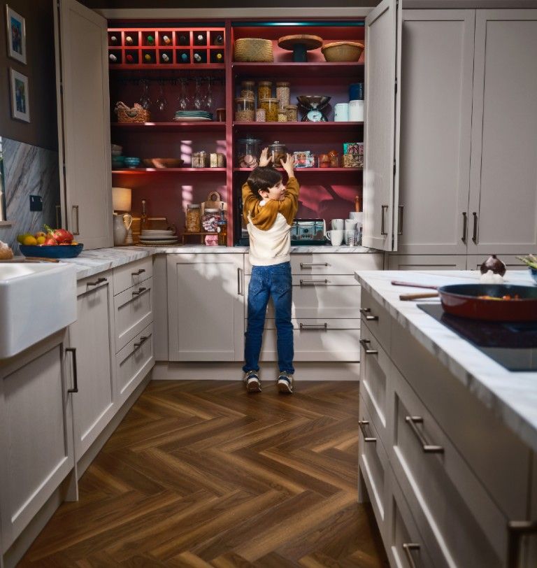 Boy at bifold with rusty red interior in Mirano Linen kitchen