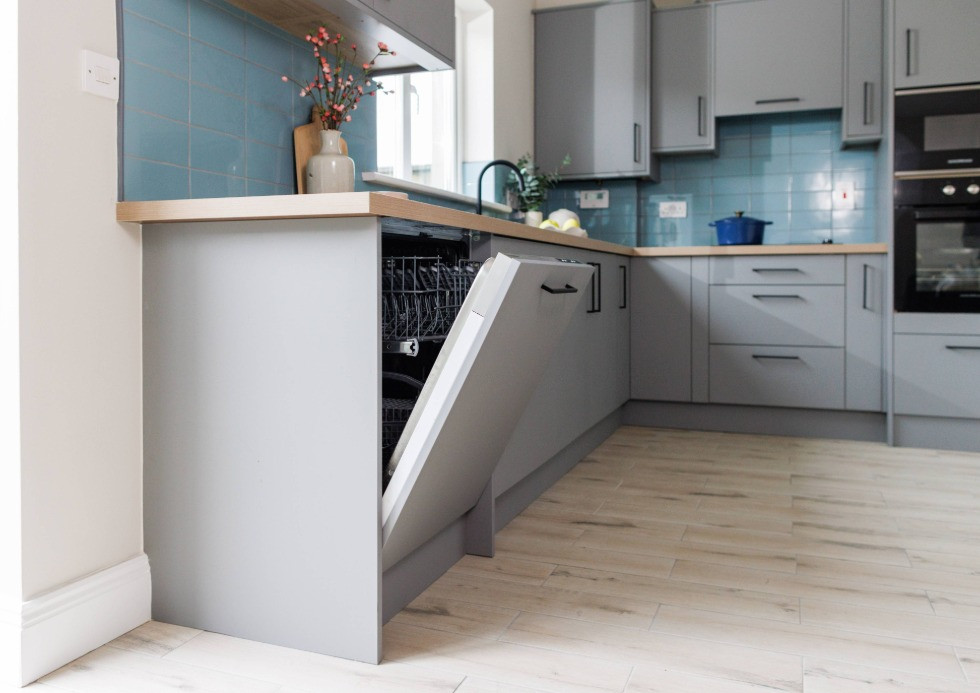 Open integrated dishwasher in modern grey kitchen