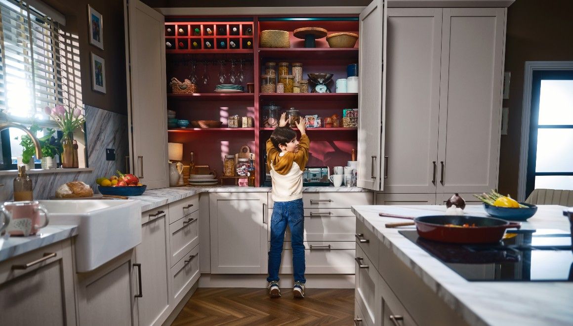 Boy at bifold with rusty red interior in Mirano Linen kitchen