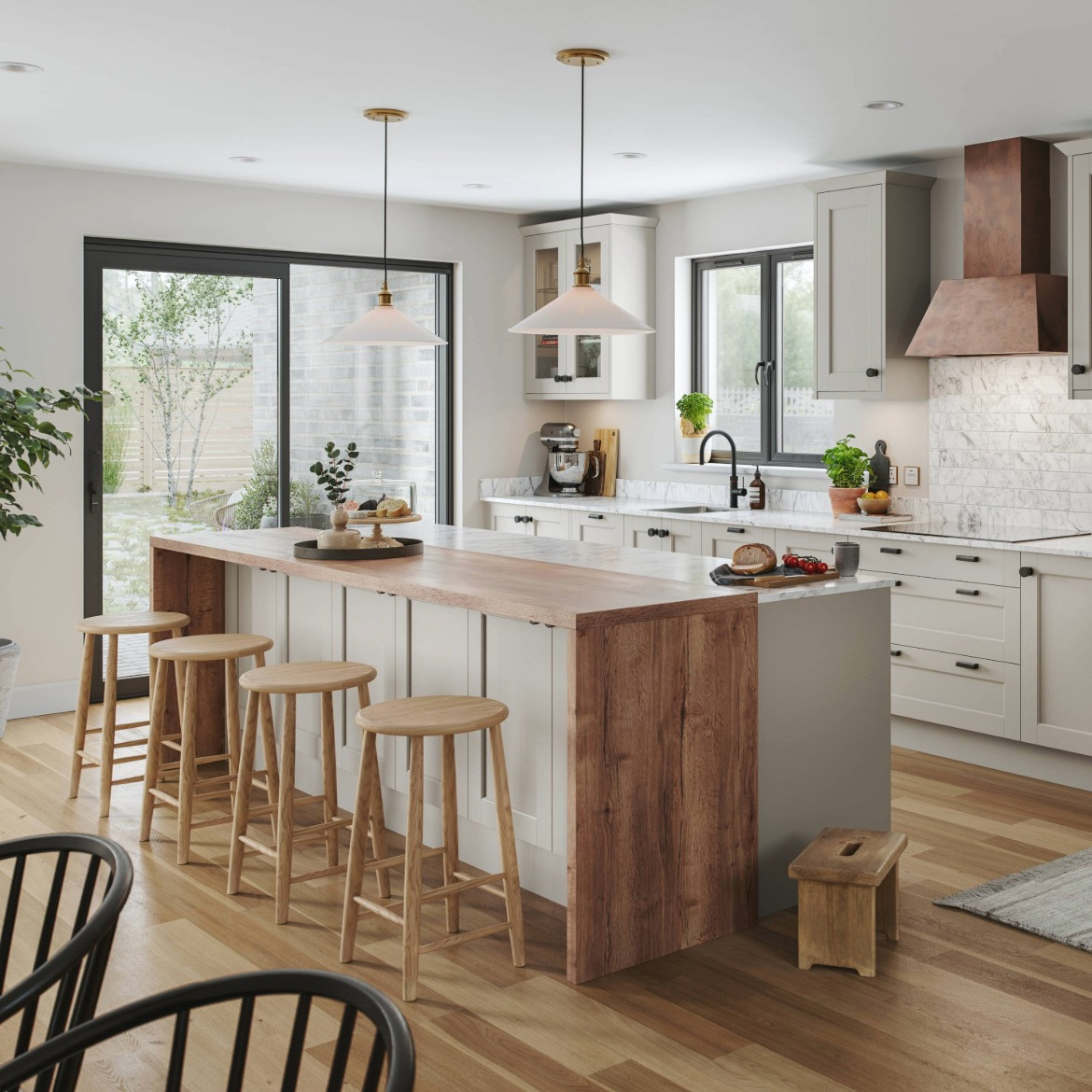 Full view of Dereham Taupe kitchen with island and stools, cabinets behind. Design includes waterfall worktop on island and Chloe Copper hood