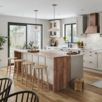 Full view of Dereham Taupe kitchen with island and stools, cabinets behind. Design includes waterfall worktop on island and Chloe Copper hood
