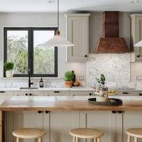 View of Dereham Taupe kitchen, background Chloe Copper Hood, window, tap and countertop, foreground island with waterfall edge on worktop