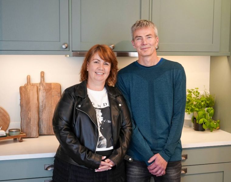 A couple inside their new Mirano Sage kitchen from Home Rescue