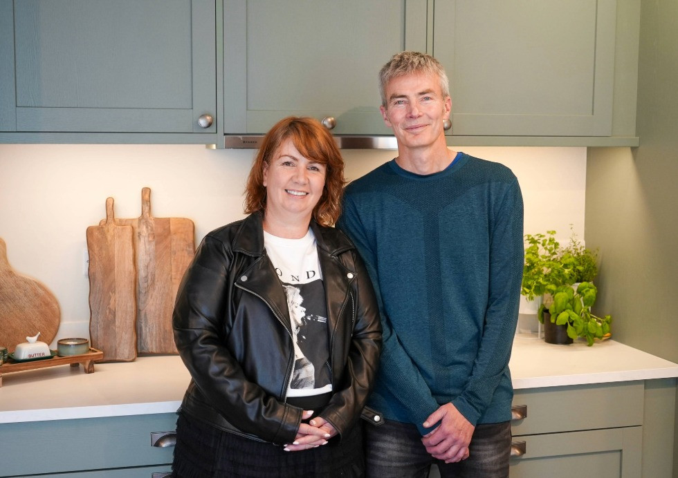 A couple inside their new Mirano Sage kitchen from Home Rescue