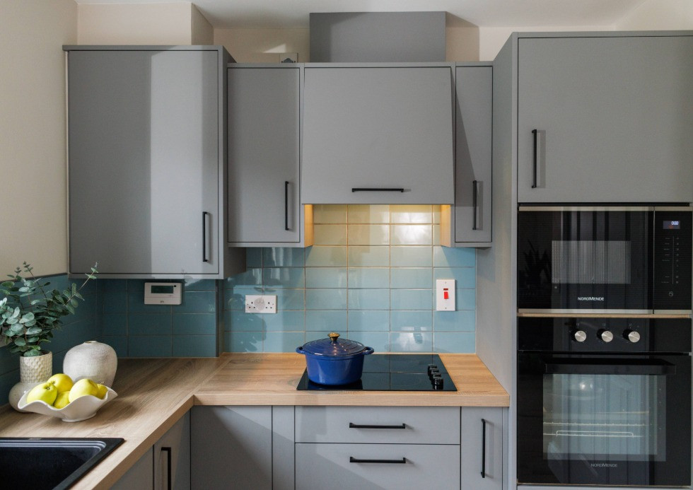Close-up of a contemporary grey kitchen with lights on