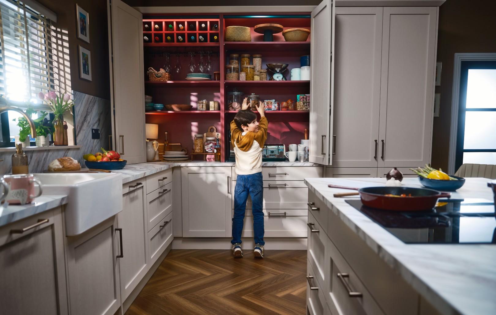 Boy at bifold with rusty red interior in Mirano Linen kitchen